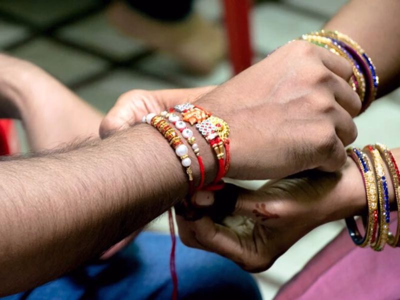Handwritten Quote on a Raksha Bandhan Card with Diya and Rakhi